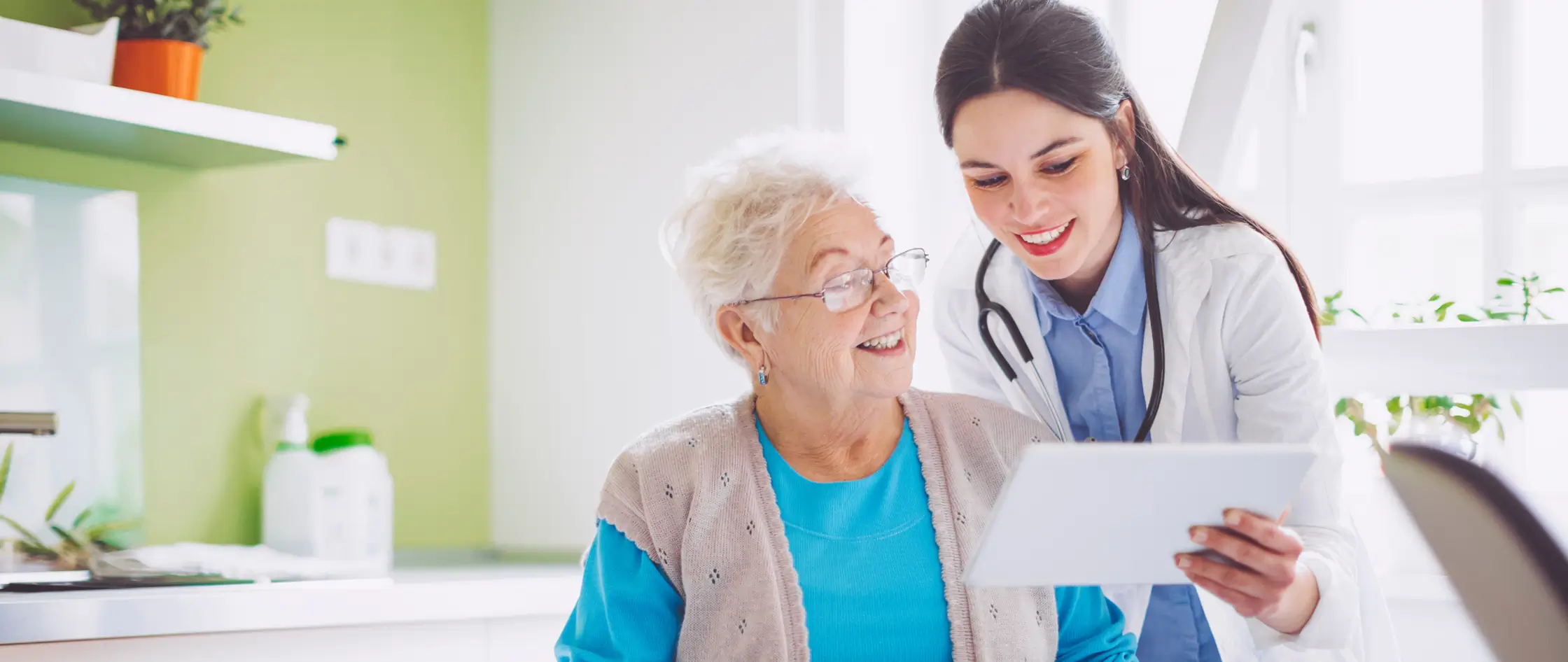 A woman and an elderly patient consult with a doctor, emphasizing compassionate care in a clinical atmosphere.