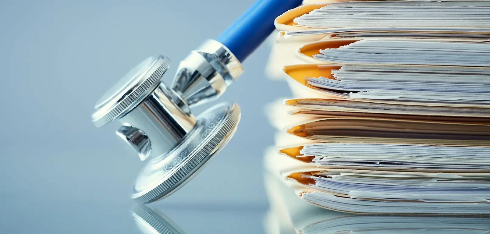 A stethoscope rests on a stack of papers, symbolizing medical documentation and healthcare practices.
